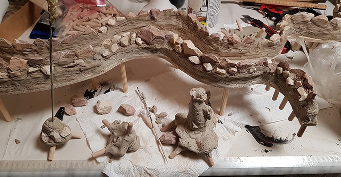 geschlängelte Ton Mauer auf Holz geklebt mit bräunlichen Steinen in den Ton